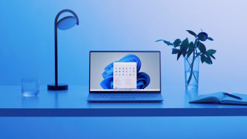 A laptop running Windows 11 placed in a fancy studio lit in blue